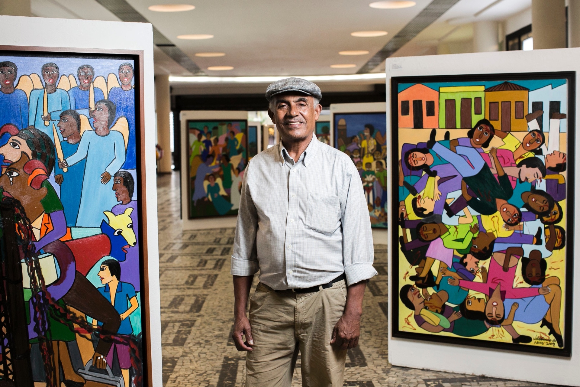 O pintor primitivista Waldomiro de Deus posa entre suas obras, em exposição no Conjunto Nacional - Leonardo Soares/UOL