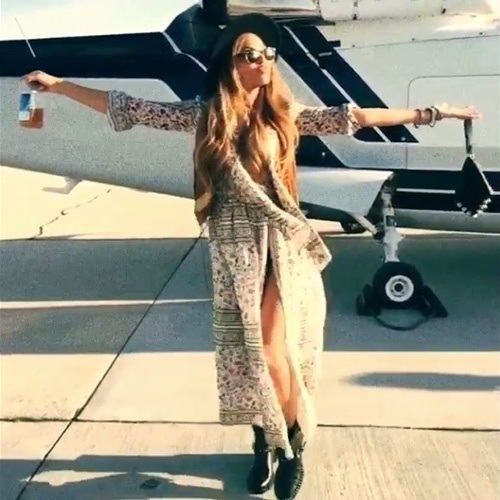 11.abr.2015 - Com fenda generosa, Beyoncé chega ao Coachella e posa com os braços abertos na frente de um avião