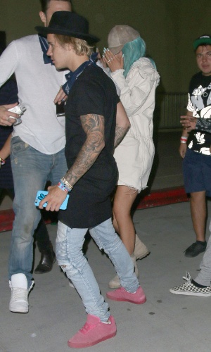 10.abr.2015 - Justin Bieber curte o primeiro dia do Coachella ao lado de Kylie Jenner (ao fundo, de cabelo azul). A irmã de Kim Kardashian não ficou à vontade com as câmeras e escondeu o rosto