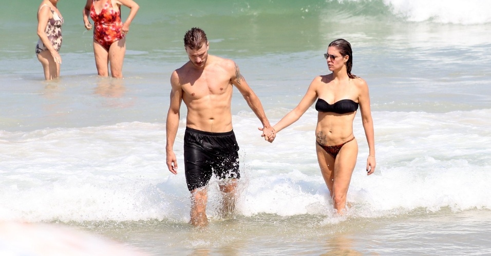 12.abr.2014 - Fernanda Lima e Rodrigo Hilbert deixam o mar de mãos dadas enquanto aproveitam dia na praia do Leblon, no Rio de Janeiro