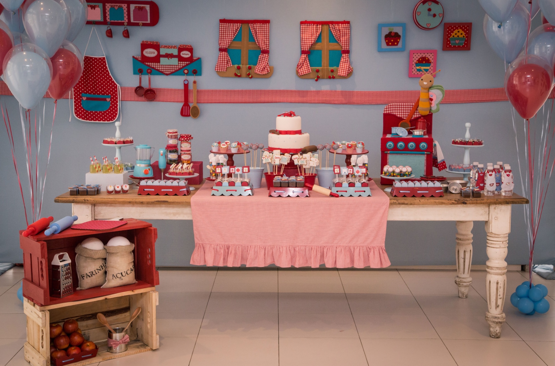 álbum com mesas decoradas | Um aniversário de um ano de menina teve como tema uma cozinha de antigamente. Tecidos com padronagem xadrez e caixotes de madeira pintados deram o tom do projeto da Caraminholando (www.caraminholando.com.br) - Divulgação