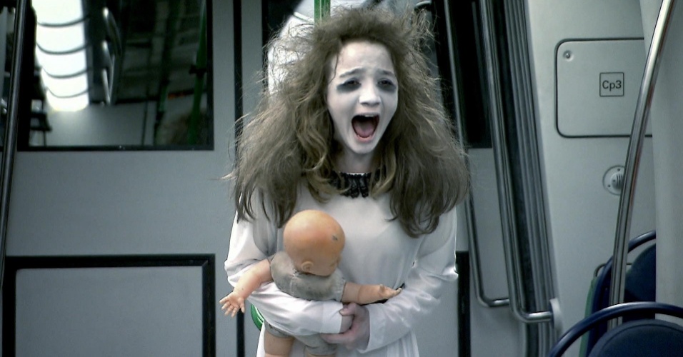 Meina Fantasma aterroriza metrô, vestida de branco, com megahair no cabelo, maquiagem branca e uma boneca nas mãos