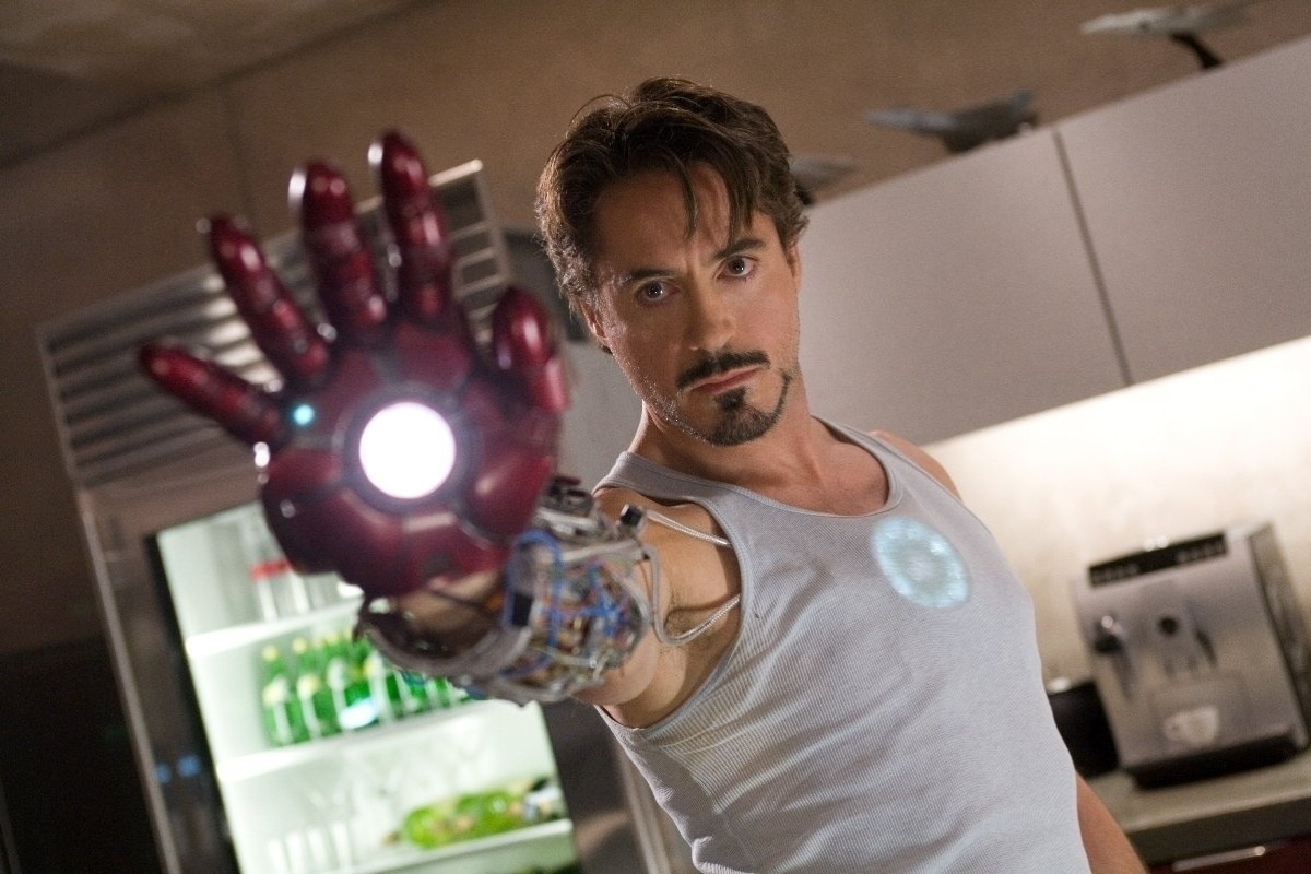 Tony Stark é o marco zero dessa empreitada. Em "Homem de Ferro" (2008) ele ainda é um playboy irresponsável, ainda que genial, capturado por terroristas para entregar seus segredos militares. No cativeiro, ele encara sua mortalidade e constrói o 1º protótipo de sua armadura com sucata e o que mais estivesse ao alcance. Ao final da trama, Tony surge com a armadura definitiva de seu alter ego, revelando em público sua identidade impossível alguém com o ego daquele tamanho não receber os louros de sua criacão. - Divulgação