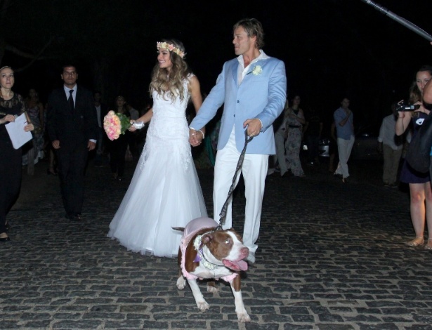 18.abr.2015- Raphaela Lamim e Theo Becker deixam a cerimônia de casamento com um cachorro da raça pitbull