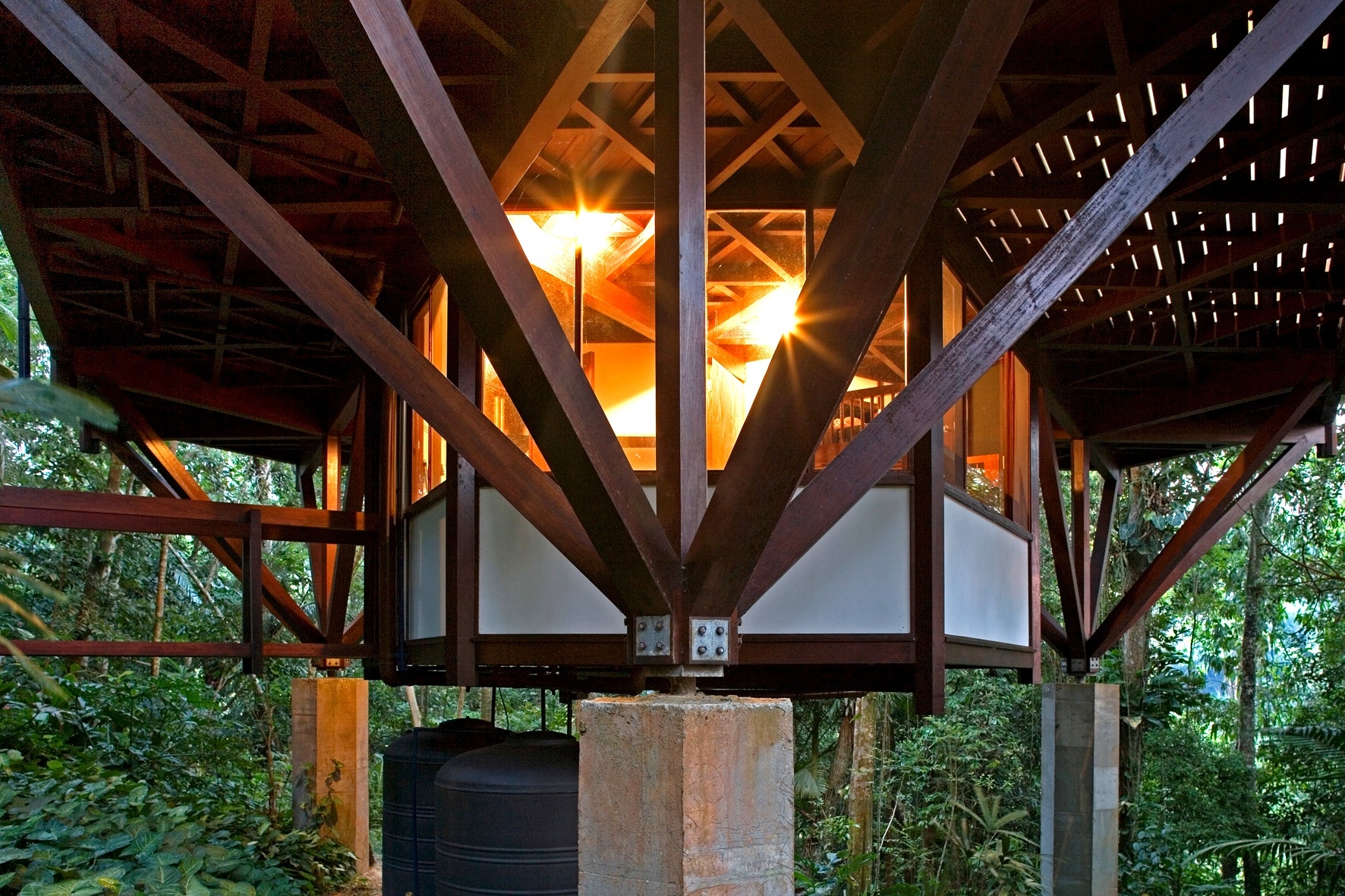 Todo o sistema de transição das cargas dos pavimentos superiores se dá através desses feixes de madeira para os três únicos pilares de concreto, reforçado por peças metálicas de conexão. O pequeno pavimento de serviço (foto) é atirantado (suspenso) e está ligado à estrutura dos andares superiores. A casa Tijucopava foi projetada pelo arquiteto Marcos Acayaba - Leonardo Finotti/ UOL