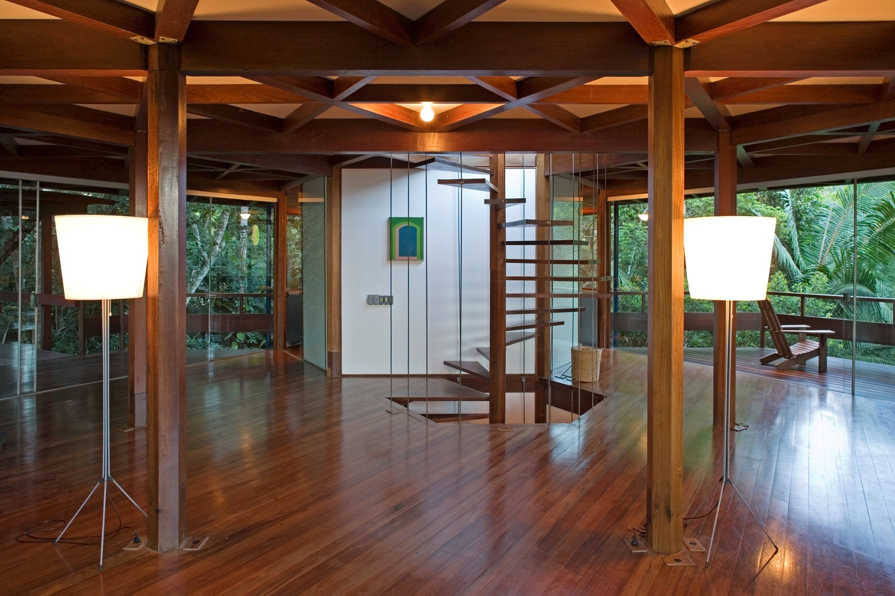 O pavimento social revela a beleza do madeiramento presente na estrutura, no piso, no forro e na escada escultural. Estar, jantar e cozinha, além de três terraços em balanço e uma ponte que faz a ligação com o estacionamento compõem esse andar. A casa Tijucopava foi projetada pelo arquiteto Marcos Acayaba e fica no litoral norte de São Paulo - Leonardo Finotti/ UOL