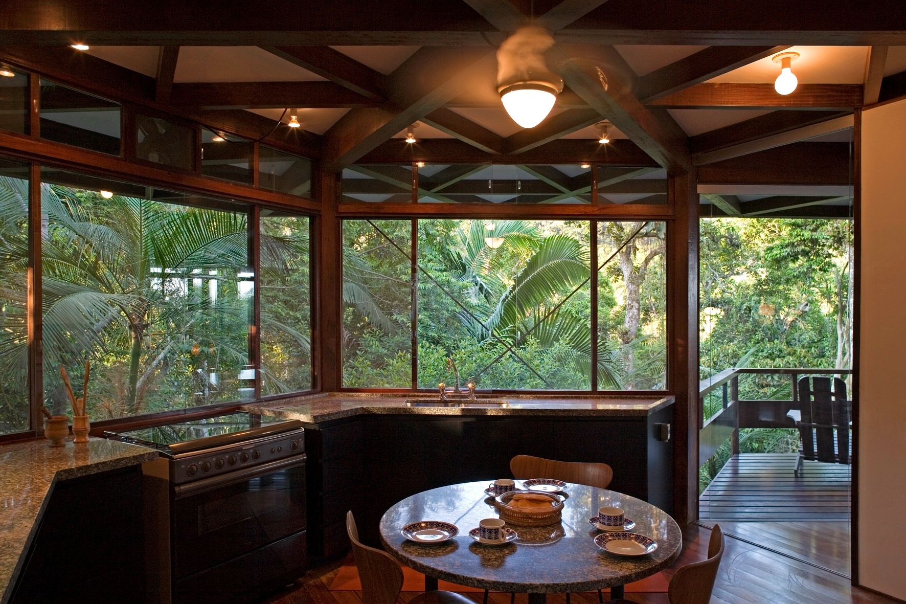 O formato hexagonal da casa Tijucopava, projetada pelo arquiteto Marcos Acayaba, favoreceu a criação de vários recantos com ambientes definidos. A cozinha é um deles: nela há uma ampla bancada de granito voltada para o exterior e uma mesa para pequenas refeições. Deste ângulo é possível observar o agradável terraço integrado - Leonardo Finotti/ UOL