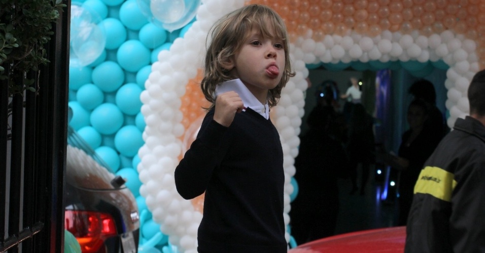 30.abr.2015- Vittorio, filho de Adriane Galisteu e Alexandre Iódice, manda língua para os fotógrafos ao chegar para o aniversário da filha caçula de Kaká em São Paulo