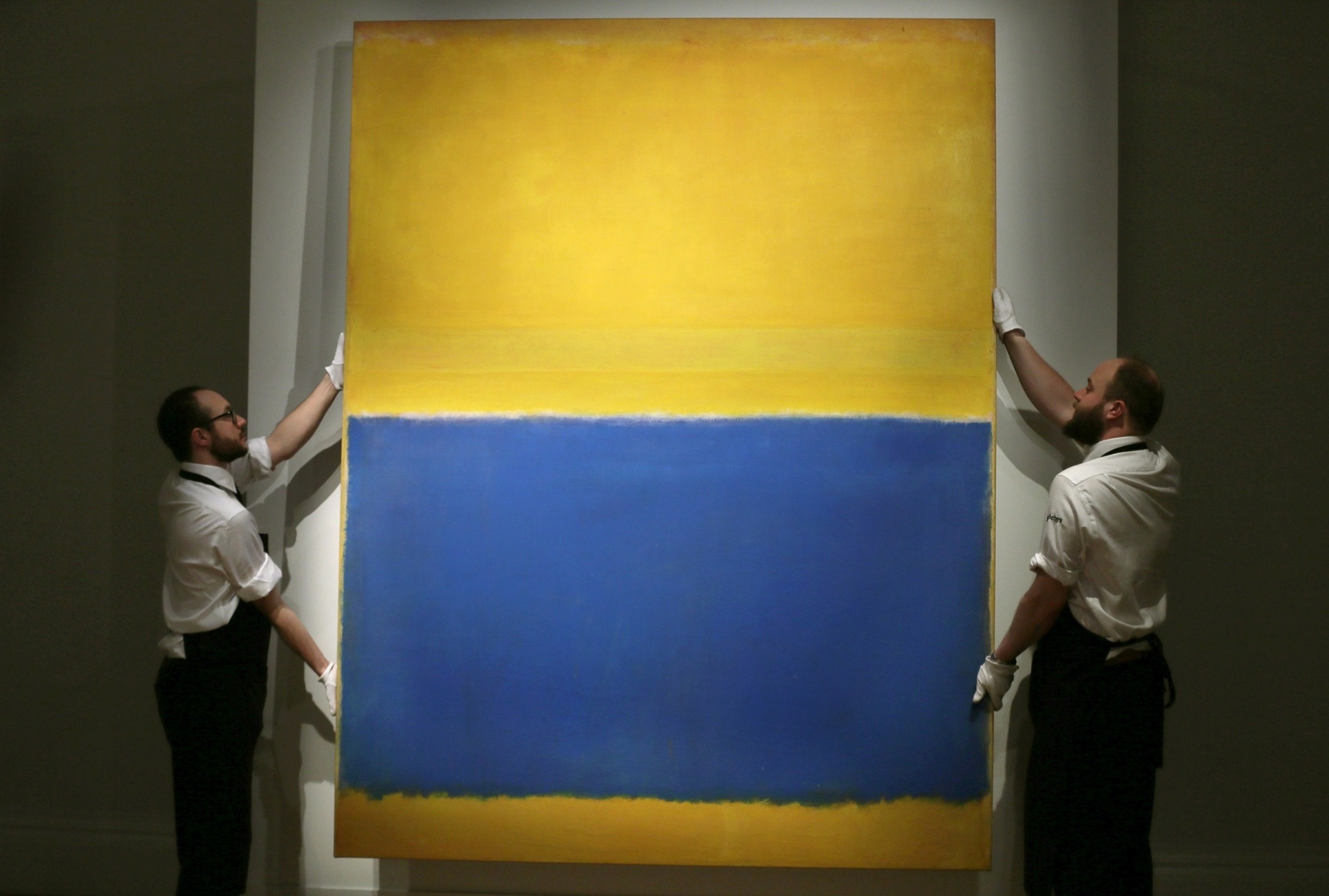 Funcionários da casa de leilão Sotheby's, em Londres, exibem a pintura "Sem Nome" (Amarelo e Azul), do norte-americano Mark Rothko, no dia 10 de abril. Em leilão realizado na unidade de Nova York da Sotheby's, a obra foi arrematada por US$ 46,5 milhões (quase R$ 140 milhões). Por dez anos, o quadro ficou pendurado na National Gallery de Washington - AP/1998 Kate Rothko Prizel & Christopher Rothko/Artists Rights Society (ARS), New York, Tim Ireland