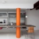 Casa térrea de 160 m² tem projeto de Guilherme Mendes da Rocha: detalhe da cozinha, cuja bancada de concreto contrasta com o pilar pintado de laranja. No piso, concreto desempenado com pintura epóxi branca - Fran Parente/ UOL