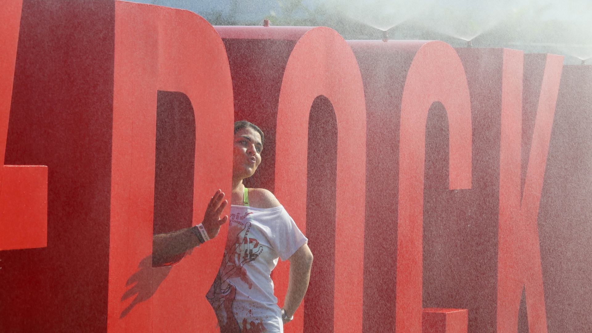 18.set.2015 - Com a temperatura batendo os 38º C e sensação térmica de 40º C, público que chega à Cidade do Rock, para curtir o primeiro dia de Rock in Rio, tenta se refrescar em fonte e já aproveita para tirar foto - Marco Antônio Teixeira/UOL