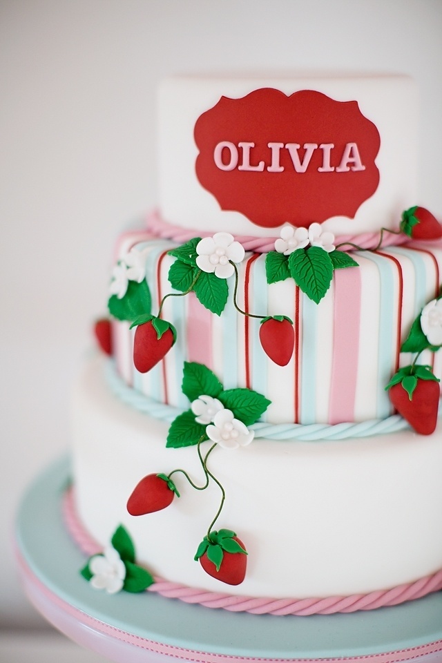 O ponto alto da festa de aniversário na menina Olivia foi o bolo, que ostentava toda a beleza de uma parreira de morangos. No topo, um selo vermelho com o nome da aniversariante - Reprodução/Pinterest