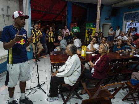 Integrantes da Cooperifa recitam poemas durante sarau em um bar no Capão Redondo - Nelson Almeida/AFP