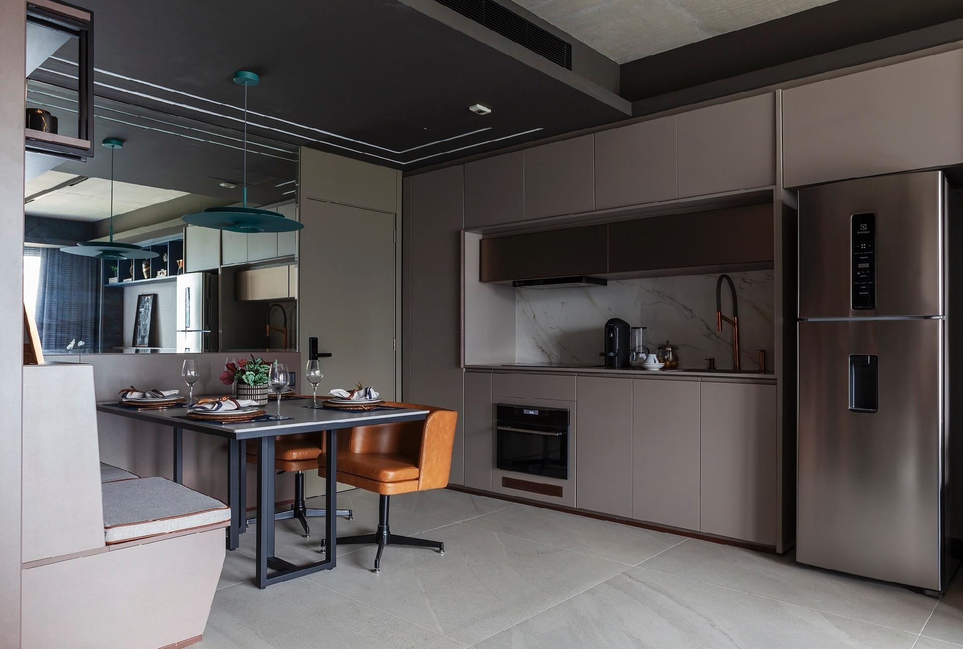 Na cozinha, armários sem puxadores tornam o visual do apartamento mais limpo, com espaço para todos os eletrodomésticos que se teria em um espaço maior. - Dotta Photo/Divulgação