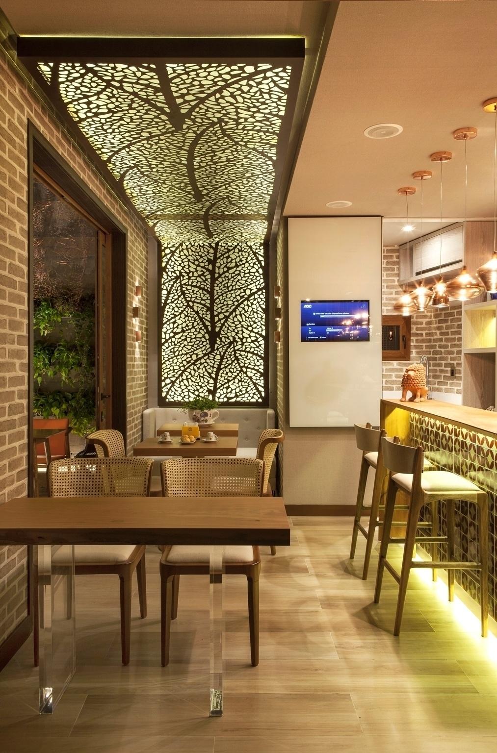 Casa Cor PE - 2016: a pequena Cafeteria Santa Clara, idealizada por Eric Dayan e Nadjânia Gomes, explora a madeira clara em todo seu mobiliário: nas cadeiras; nas banquetas Helga (à dir.), do estudiobola; e nos tampos tanto do balcão quanto das mesas. Esta da frente, aliás, tem pés de acrílico, que quebram a rusticidade predominante do espaço - Felipe Araújo/Divulgação