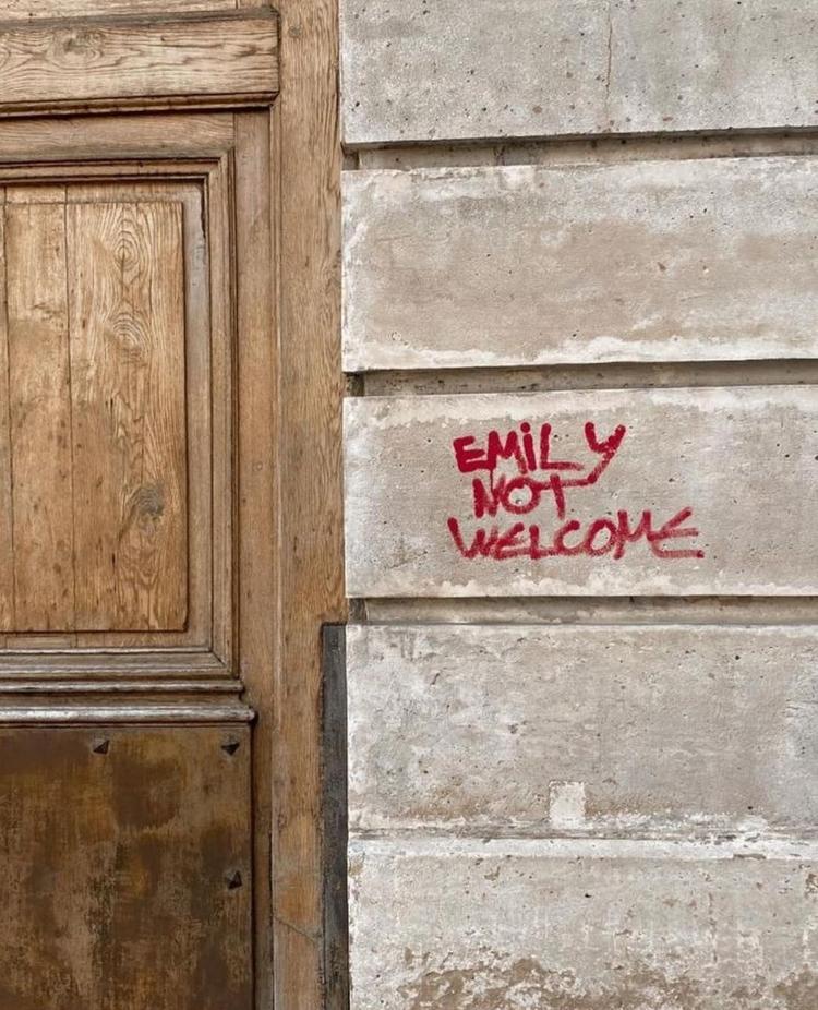 Muro de prédio onde acontecem gravações de 'Emily in Paris' com pichação contra a série