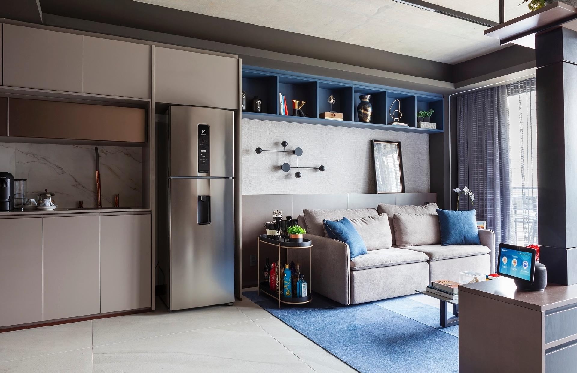 Do outro lado da sala, o estar ficou amplo e recebeu um sofá-cama que pode acomodar visitas caso seja preciso dormir. Atrás desse móvel, surpresa: o painel tem um nicho interno para guardar itens de limpeza, como rodos e vassouras. - Dotta Photo/Divulgação