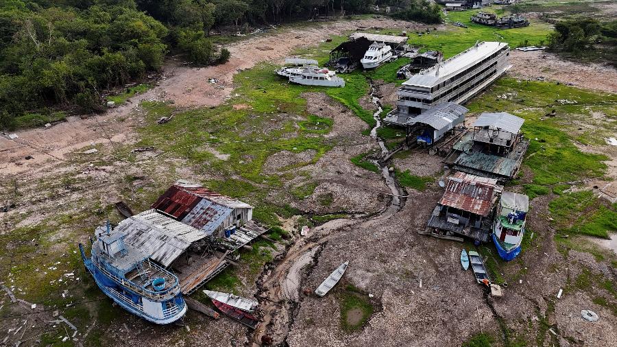 Vista aérea mostra casas flutuantes e barcos sobre o leito seco do rio Tarumã-Açu, afluente do rio Negro, próximo a Manaus