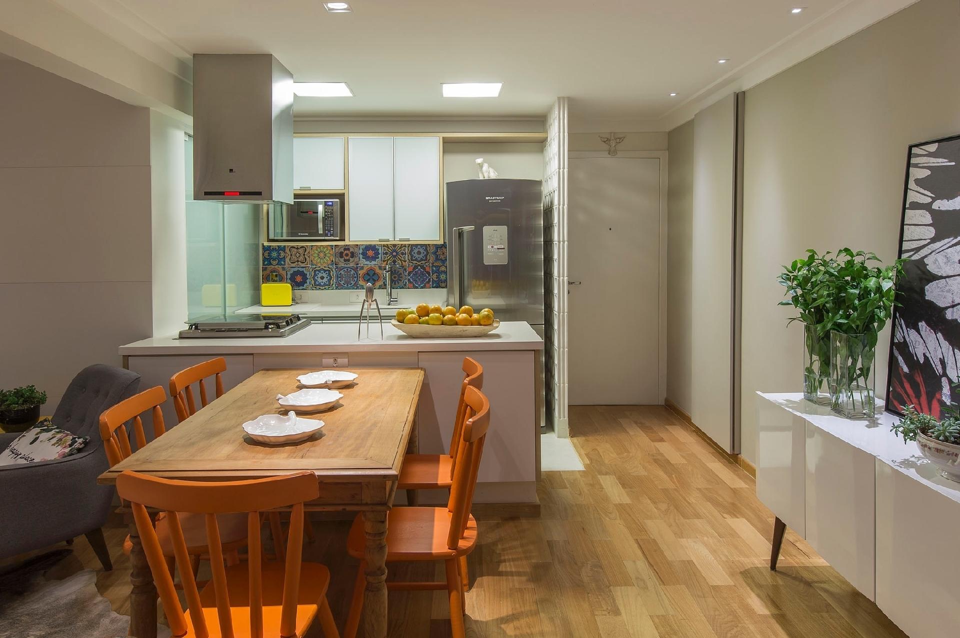 A arquiteta Idália Daudt aproveitou parte dos móveis rústicos da família para criar uma decoração com toque moderno, pintando as cadeiras de laranja para se destacarem e misturando as peças a elementos mais contemporâneos, como o bufê. A posição da mesa, perpendicular à ilha da cozinha, favorece a circulação no dia a dia e também possibilita a acomodação de mais uma pessoa quando preciso - Salvadore Busacca/Divulgação