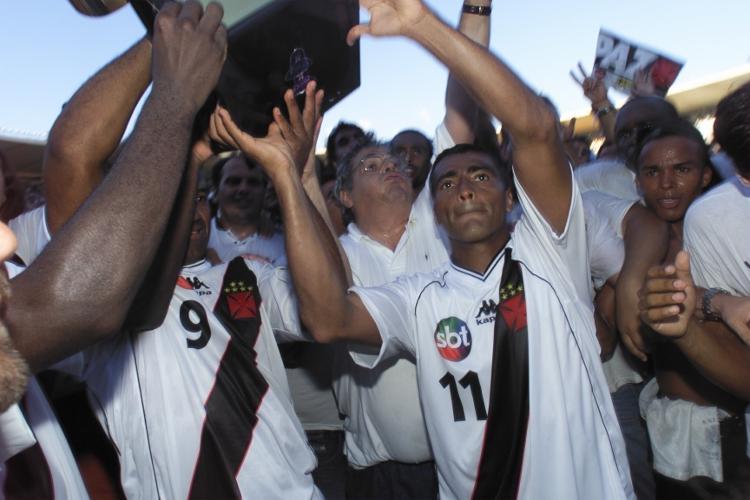 Eurico Miranda (ao fundo), Romário e Viola erguem o troféu da Copa João Havelange 2000, vencida pelo Vasco, que jogou com o logotipo do SBT na camisa