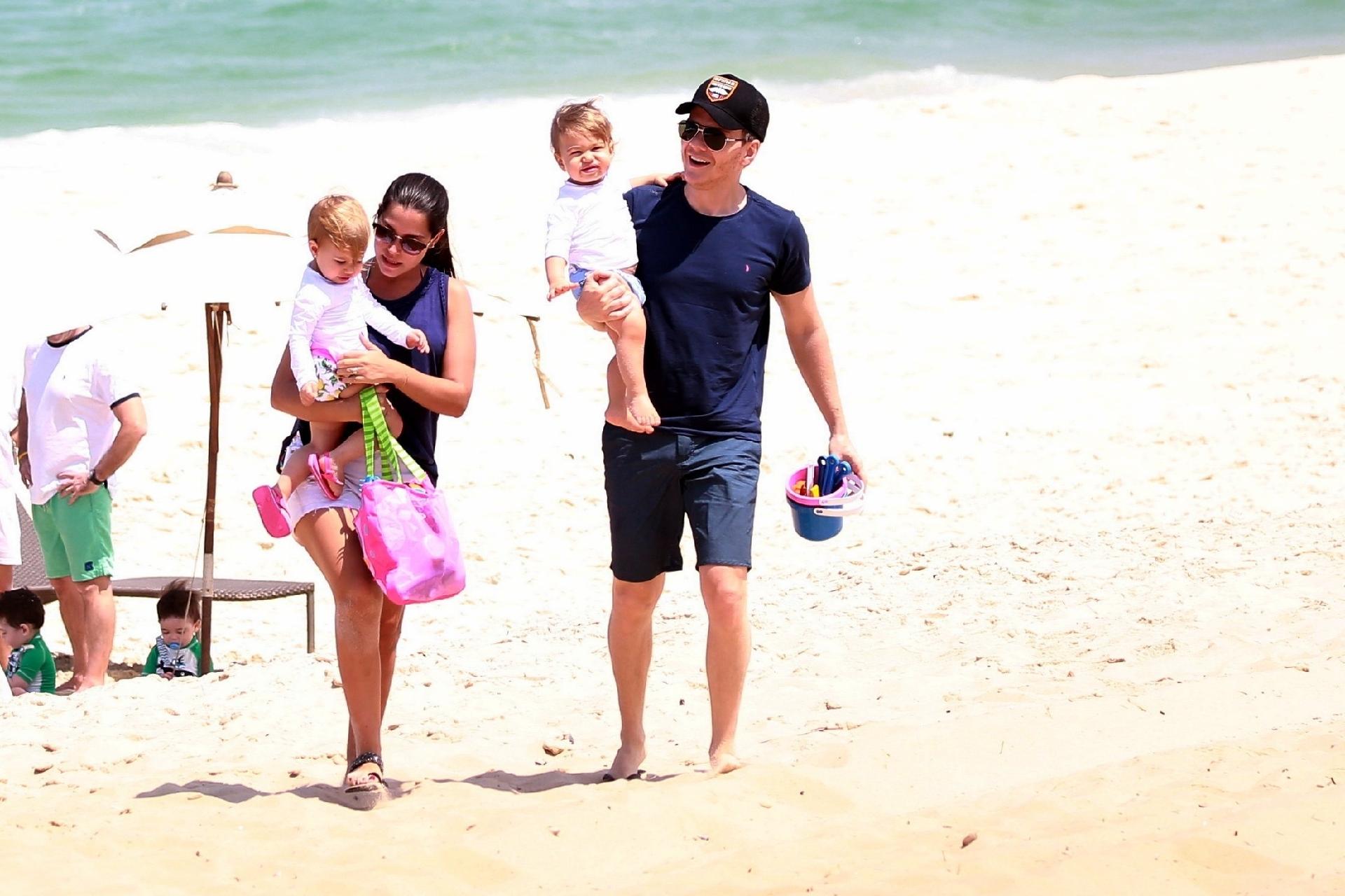 Teló e Thais deixaram a praia com os pequenos no colo um pouco antes do almoço. Apesar do calor, os dois não entraram no mar - AgNews