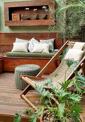 O vaso de xanadu (Philodendron 'xanadu'), em primeiro plano, faz parte da ambientação do deck de madeira de demolição, que abriga bancos e cadeira de corda. No espaço há, também, um vaso com um exemplar de oliveira (Olea europaea L.). O jardim mede cerca de 50 m² e teve o paisagismo definido por Gigi Botelho - Divulgação