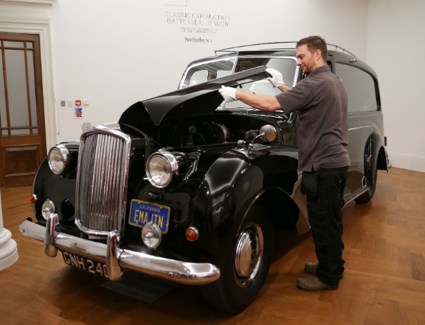 Funcionário da casa de leilões Sotheby prepara o Austin Princess de 1956 para leilão - Daniel Leal-Olivas/AFP