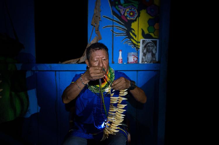 Isidro prepara o colar de dentes de queixada para a cerimônia do Yagé - PEDRO PARDO/AFP - PEDRO PARDO/AFP