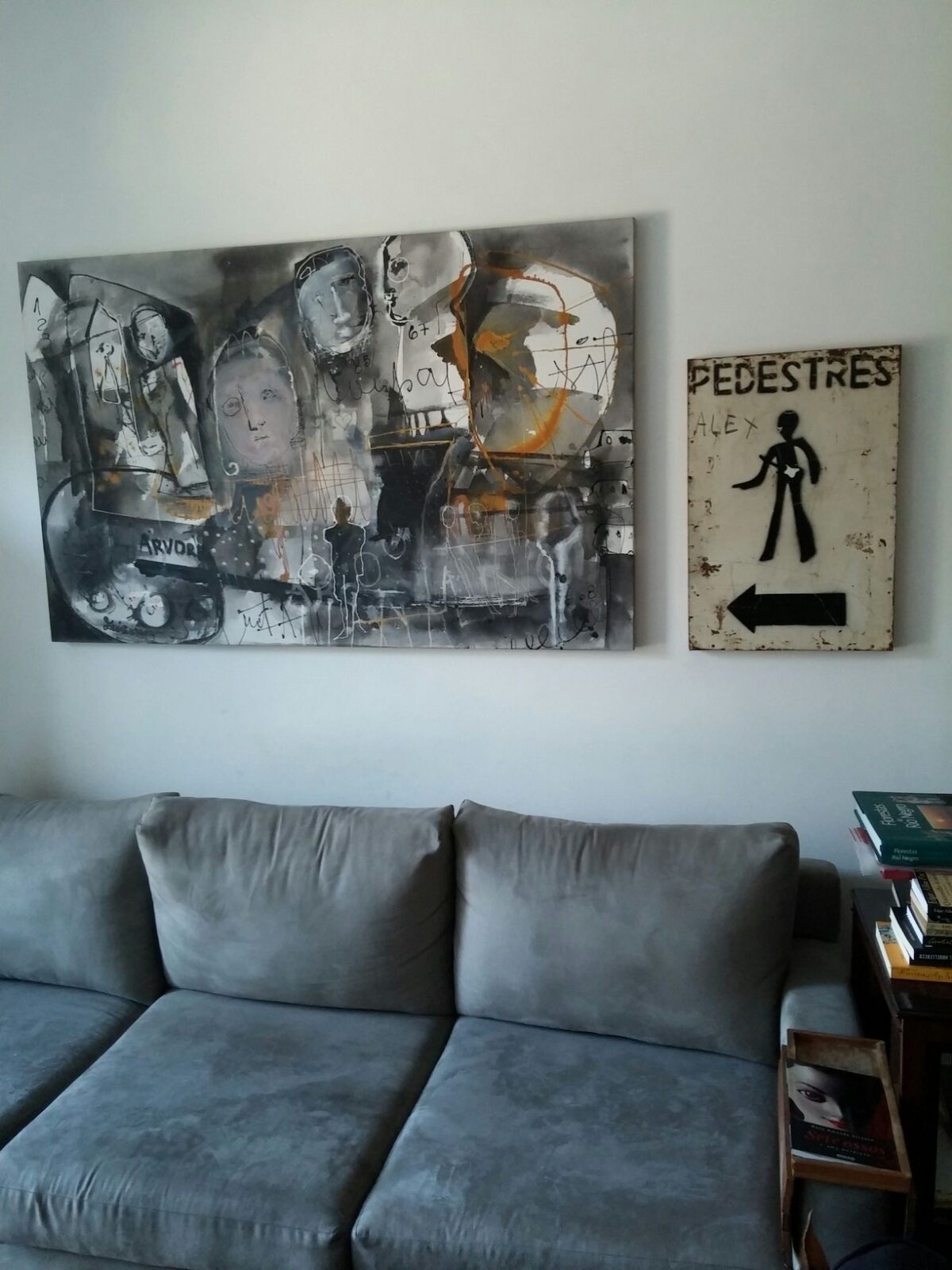 A escritora Rosa Amanda Strausz encontrou uma placa de obra descartada na rua e resolveu levar para sua casa. Ao lado da tela da artista plástica Edineusa Bezerril, a inusitada peça (à dir.) decora a sala de estar - Divulgação/ Arquivo pessoal