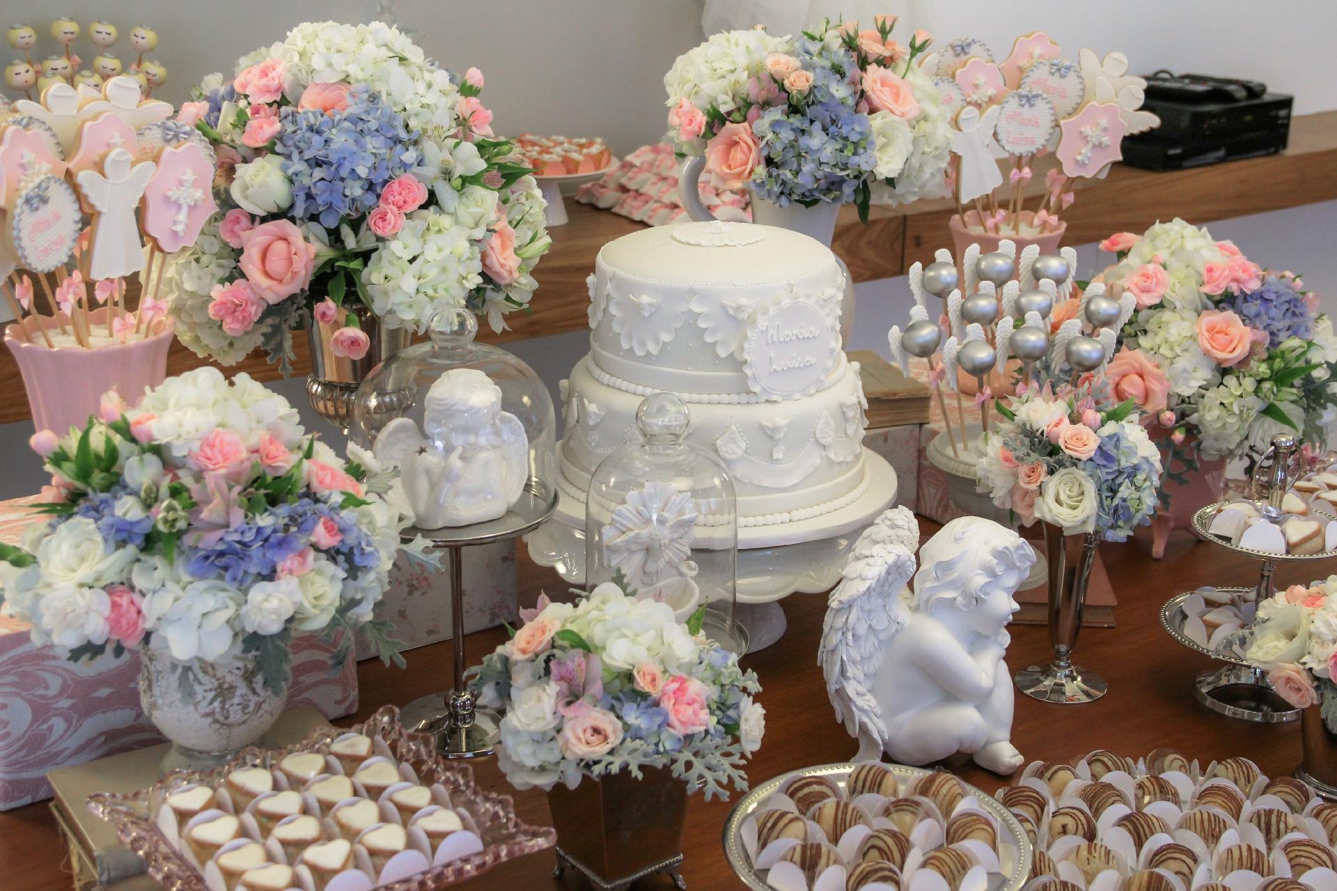 Além dos anjinhos e arranjos florais, Fabiana Moura - Projetos Personalizados também fez um mix de travessas entre prataria, cristal e porcelana na mesa do batizado - Divulgação