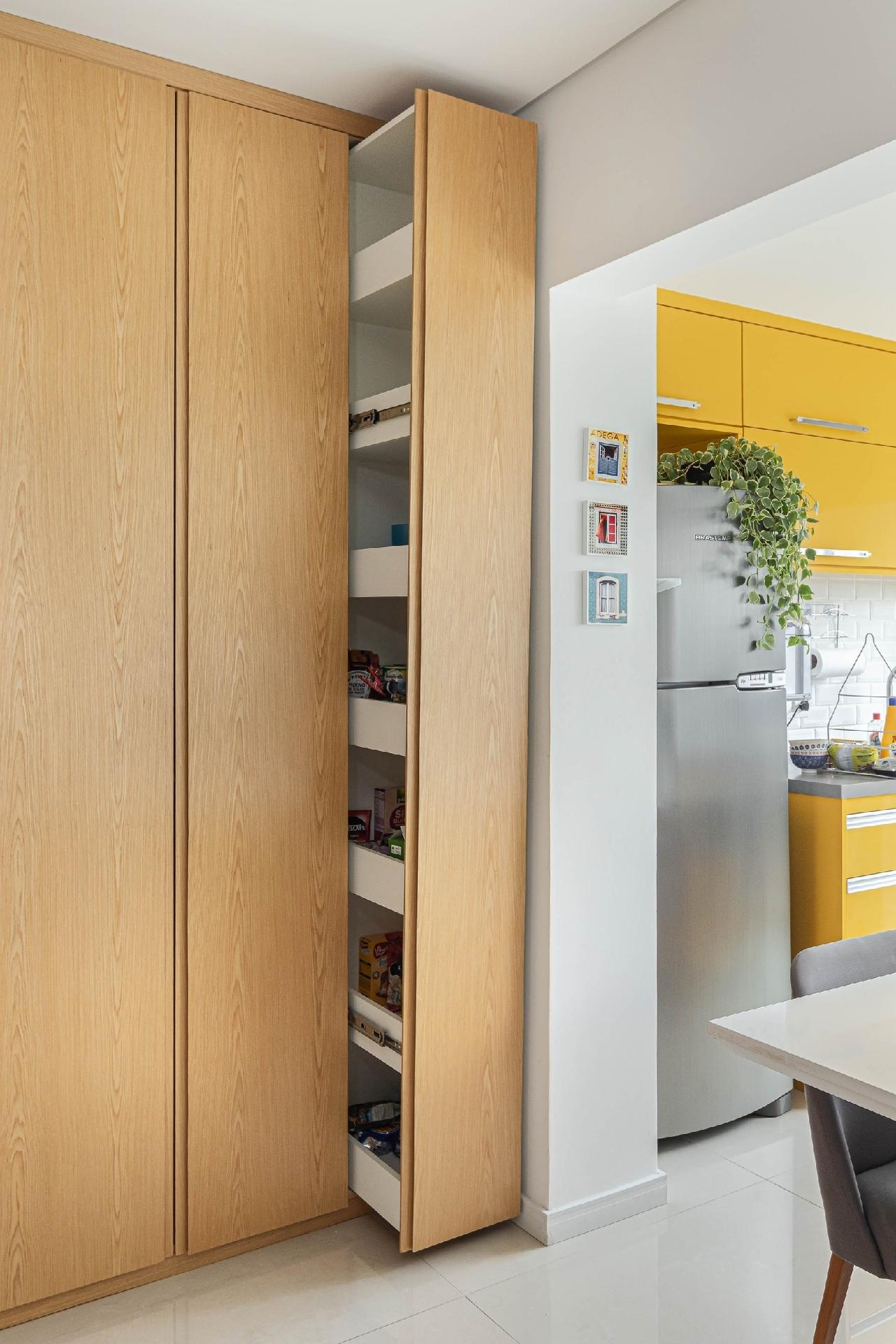 "Boas ideias" que fala? O apartamento de 48 m² projetado pela arquiteta Lucilla Mesquita tem ótimas sacadas para aproveitamento de espaço, como as prateleiras camufladas sob o armário de marcenaria. A porta é de correr e foi instalada junto ao armário de marcenaria. Dentro, sete divisórias acomodam alimentos não perecíveis, deixando tudo organizadinho. - Gisele Rampazzo