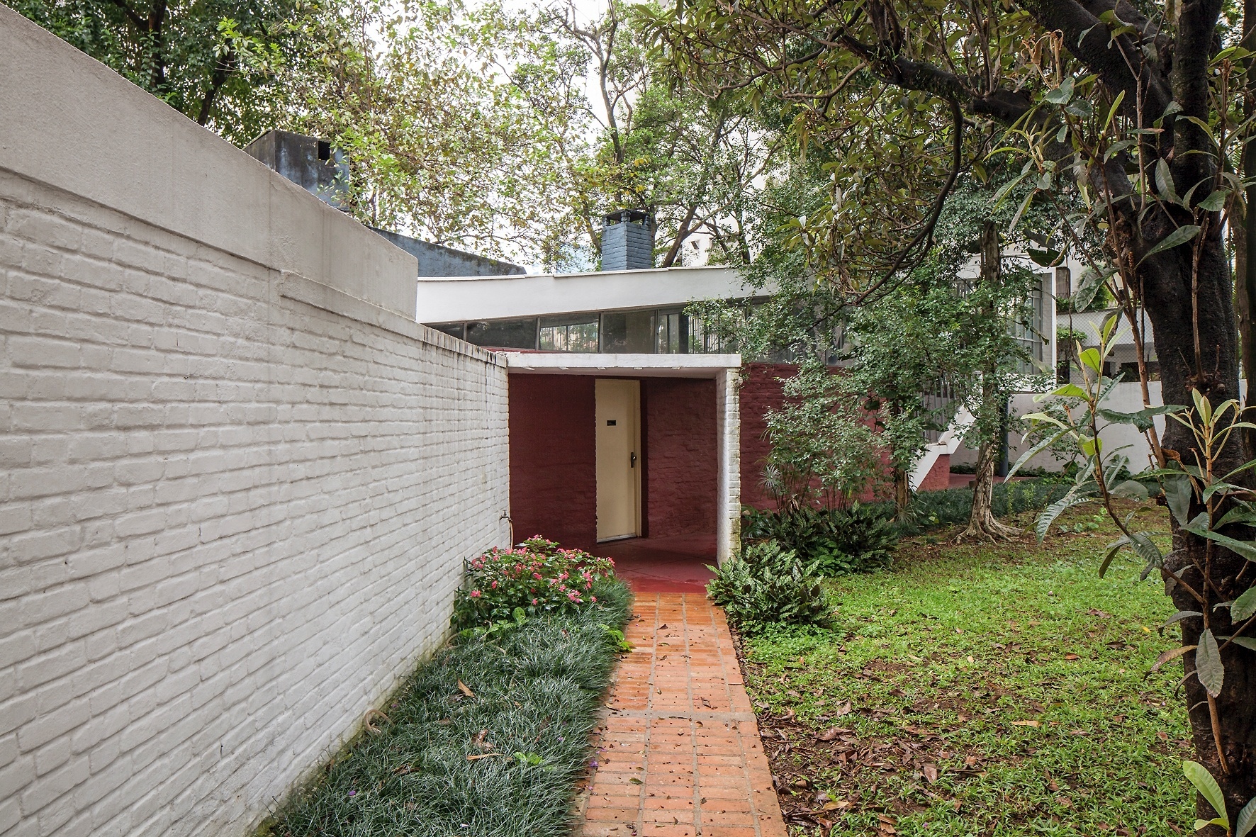 Disposto a 45 graus em relação ao corpo principal da Casa do Arquiteto (1949), o bloco de entrada é composto por garagem coberta por abóbada, lavanderia e hall. A residência foi projetada por João Batista Vilanova Artigas (1915-1985) e é influenciada pelo racionalismo de Le Corbusier (1887-1965) - Leonardo Finotti/ UOL