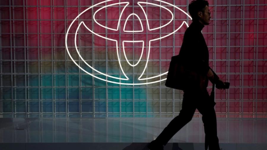 Homem passa por luminoso com logotipo da Toyota
