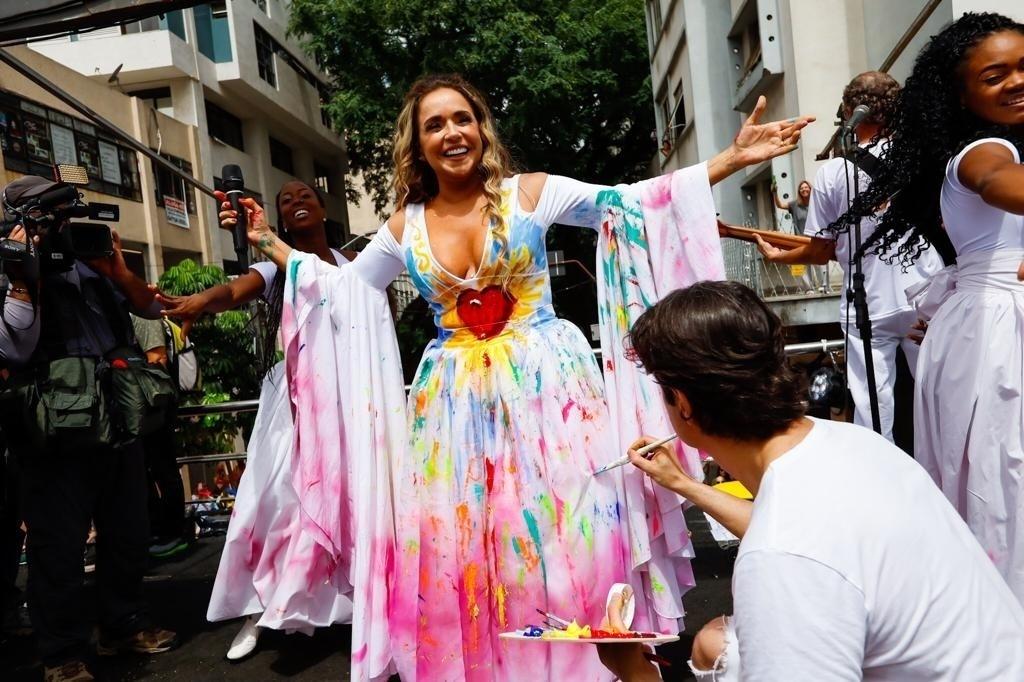 Artista pinta vestido branco de Daniela Mercury durante desfile do bloco Pipoca da Rainha, na rua da Consolação, em São Paulo - Marcelo Justo/UOL