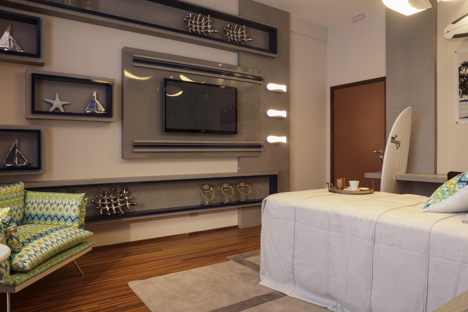 1 - Quarto do surfista. Na parede que apoia a TV, nichos em diferentes tamanhos abrigam objetos de decoração inspirados no cenário praiano. O espaço é uma criação da arquiteta Hellen Caroline Giacomitti. A Casa Cor Paraná fica em cartaz até dia 9 de agosto de 2015, na Rua Fernando Amaro, 60, em Curitiba. Outras informações: www.casacor.com.br - Daniel Sorrentino/ Divulgação