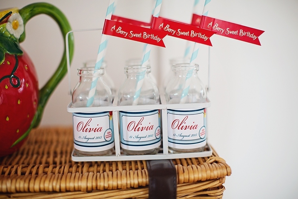 Ao lado da jarra no formato de morango, tema desta festa de aniversário infantil, garrafinhas personalizadas com o nome da aniversariante e tags que desejavam "a berry sweet birthday" (um aniversário doce como a fruta, em tradução livre do inglês) - Reprodução/Pinterest