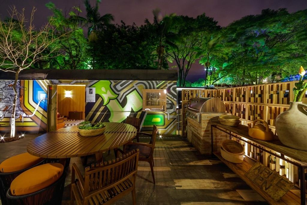 Na área do deck há espaço para festas ao ar livre e reuniões para curtir um belo churrasco. O cantinho gourmet foi equipado com churrasqueira inox da Home and Grill e móveis da Saccaro. Ao fundo, o vagão de trem, recuperado e grafitado externamente pelo coletivo Vollume BR - Divulgação