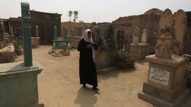Moradora da Cidade dos Mortos anda entre os túmulos deste cemitério do Cairo - REUTERS/Amr Abdallah Dalsh - REUTERS/Amr Abdallah Dalsh