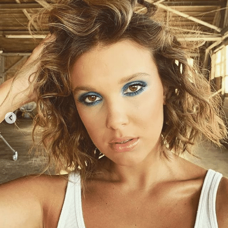 A estrela de Stranger Things compartilhou duas fotos em que aparece usando uma sombra azul bem esfumada e cabelos ondulados - Reprodução/Instagram
