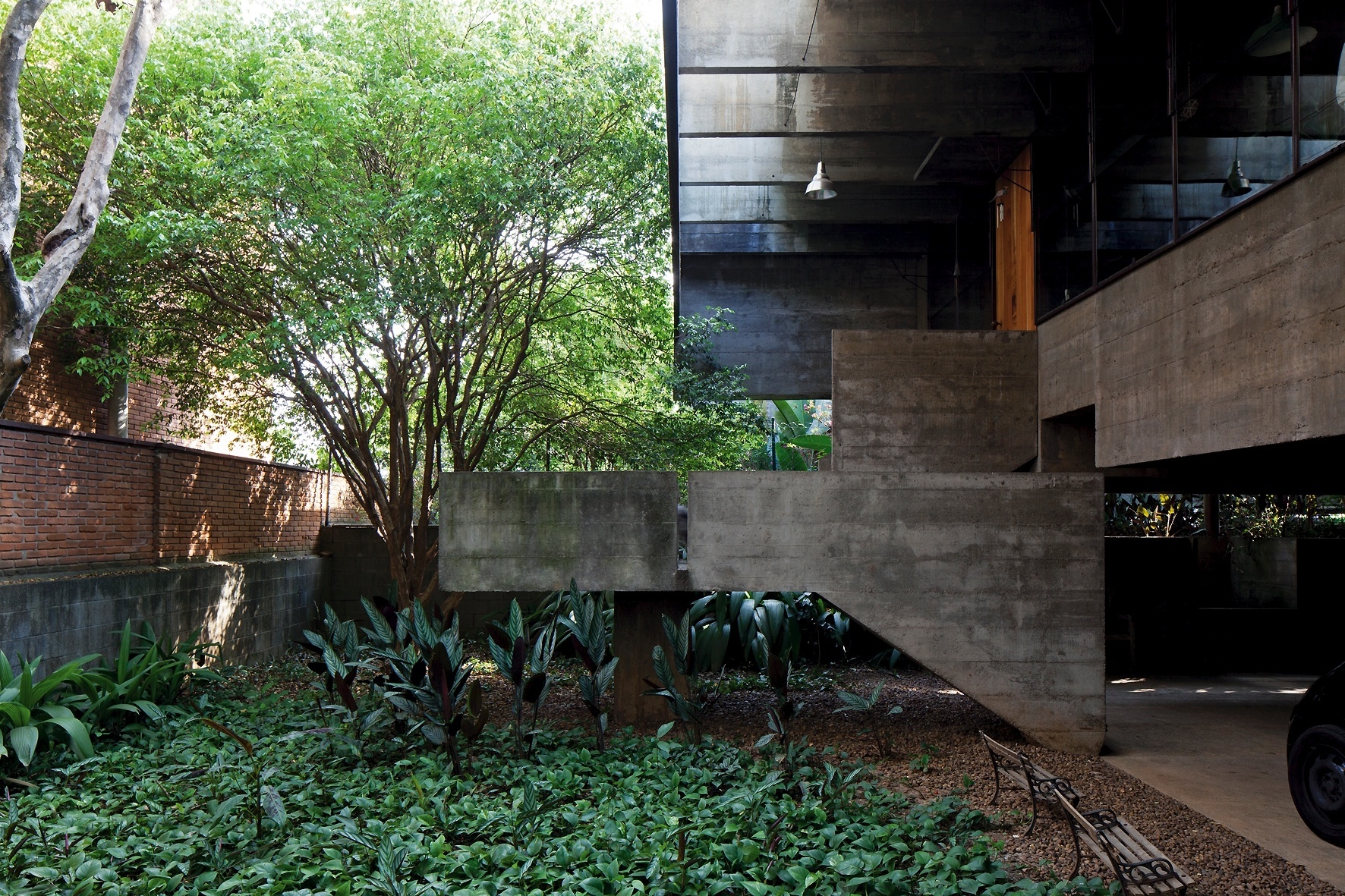 O térreo da casa Butantã, projetada por Paulo Mendes da Rocha, é uma praça que combina concreto e jardim, onde se situa a escada que dá acesso ao pavimento superior e principal. Destaque para o beiral, com pergolado em balanço de três metros - Leonardo Finotti/ UOL