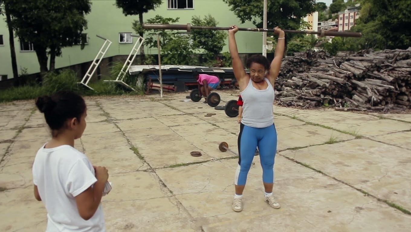 "Bete do Peso" (Dir.: Kiko Mollica, Brasil, 26', 2014) :: Ex-lavadeira, aos 43 anos Maria Elisabete Jorge foi a primeira levantadora de peso a defender o Brasil numa Olimpíada. Isto aconteceu em Sidney (2000). Então será exibido na sessão o curta ?Meninas?, - Reprodução