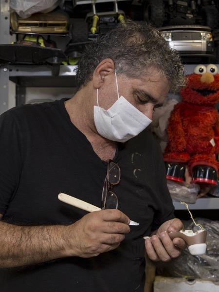 Bartolomeu analisa um sugador quebrado. Ele diz que tem recebido mais aparelhos do modelo para consertar