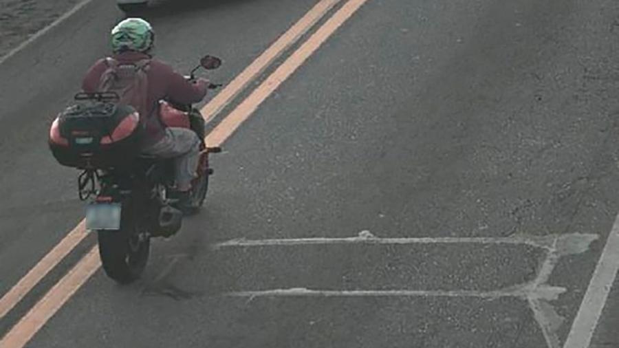 Foto de suposto auto de infração mostra motociclista tentando desviar dos laços, sensores de medição de velocidade instalados no asfalto