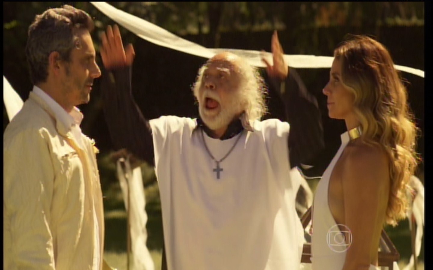 10.mar.2016 - Vestido de padre, Ascânio (Tônico Pereira) celebra o casamento de Romero (Alexandre Nero) e Atena (Giovanna Antonelli) em "A Regra do Jogo" - Reprodução/Globo