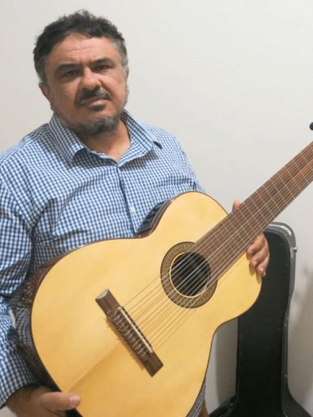 Reinaldo Casteluzzo com sua invenção: um violão de 12 cordas, que pode ser tocado com uma só mão - ARQUIVO PESSOAL