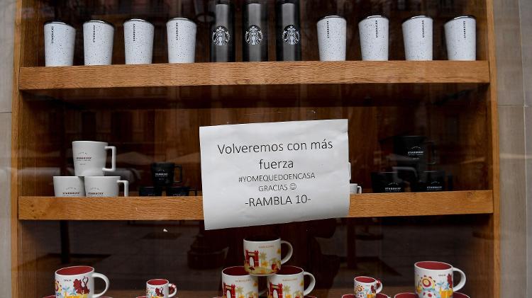 14.03.2020 - "Voltaremos com mais força", diz o cartaz afixado na cafeteria em Barcelona - Josep Lago/AFP