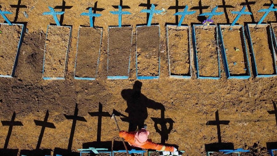 Foto aérea tirada em 2 de junho de 2020 mostra um coveiro parado no cemitério de Nossa Senhora Aparecida, onde vítimas do covid-19 são enterradas diariamente, no bairro de Taruma, em Manaus, durante pandemia do coronavírus - Michael Dantas/AFP