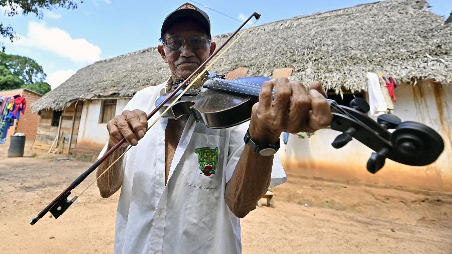 Hildeberto Oreyai toca violino fora de sua casa na cidade de Urubicha, na Bolívia