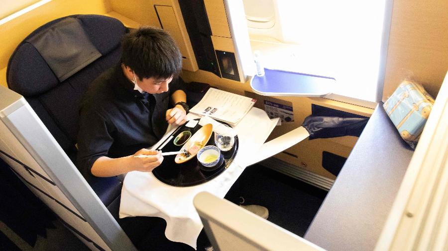 Passageiro consome refeição em avião da All Nippon Airways - All Nippon AIrways (ANA)/ AFP