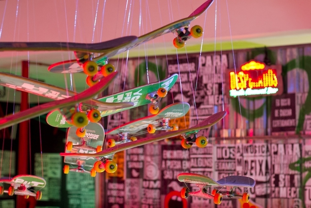 Detalhe dos skates pendurados no teto. Cenografia é assinada pelo Estúdio Xingu - Divulgação